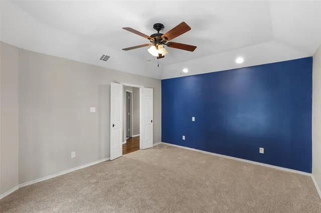 a view of an empty room with a ceiling fan and a window