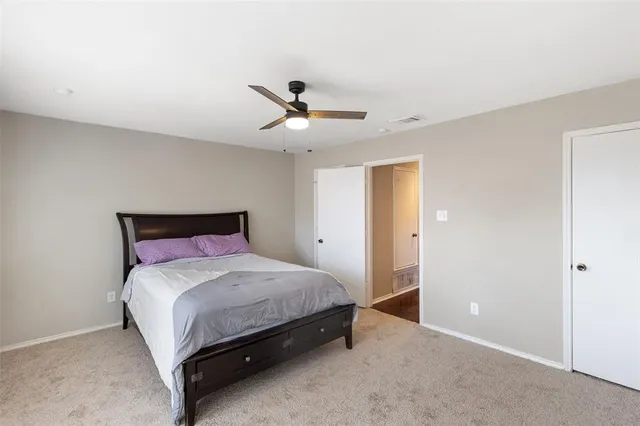 a bedroom with a bed and a ceiling fan