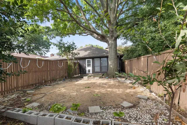 a view of a barn house next to a yard with wooden fence