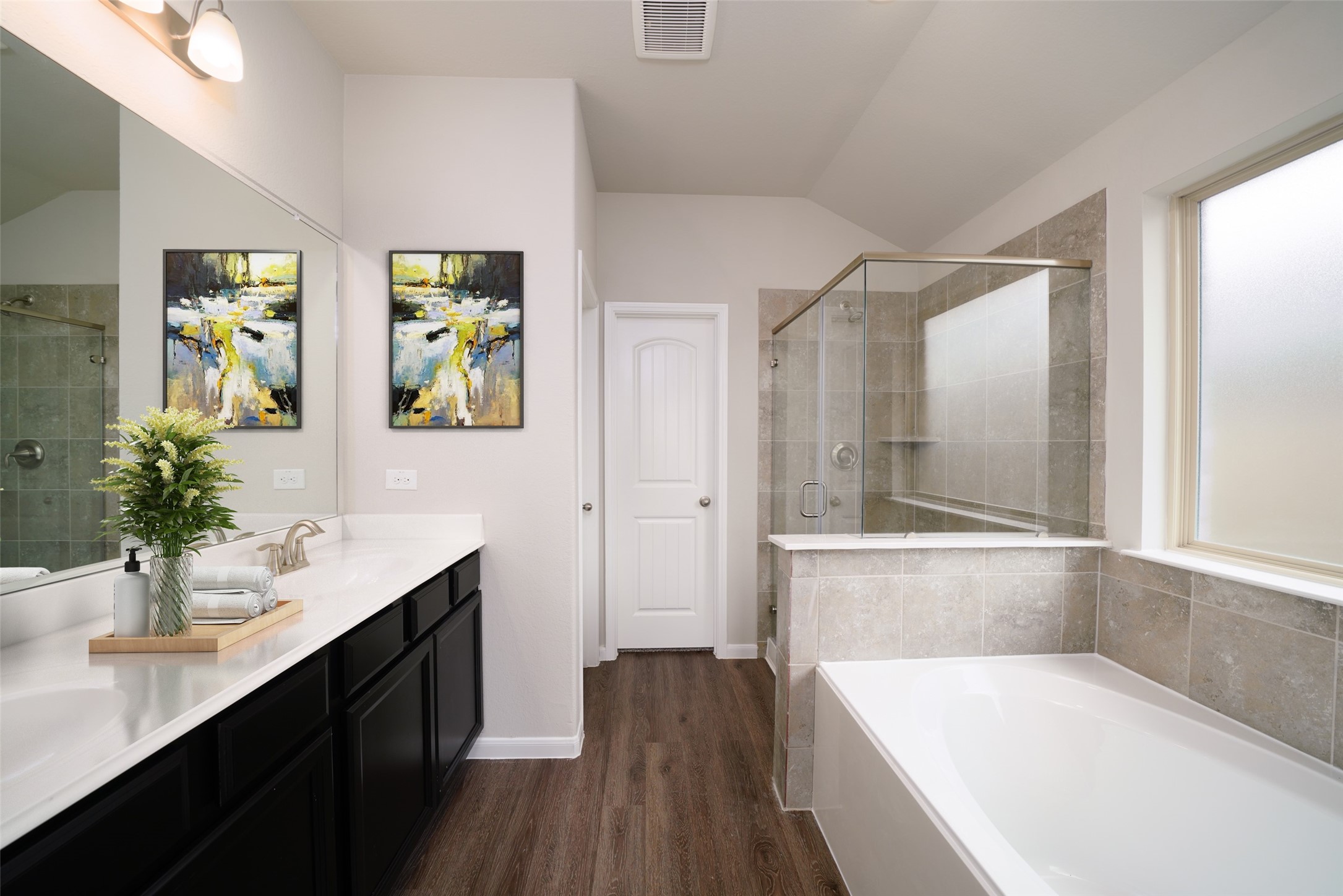 19632 Montgomery Rdg Way Montgomery, TX 77316 - Photo 9 of 9 A spacious primary master bath featuring a stylish vanity with light-colored countertops, offering a clean and elegant look. The bath includes a walk-in shower with a beautifully tiled surround, and a separate soaking tub, creating a relaxing and functional space for daily use. Sample photo of completed home with similar floor plan. As-built interior colors and selections may vary.