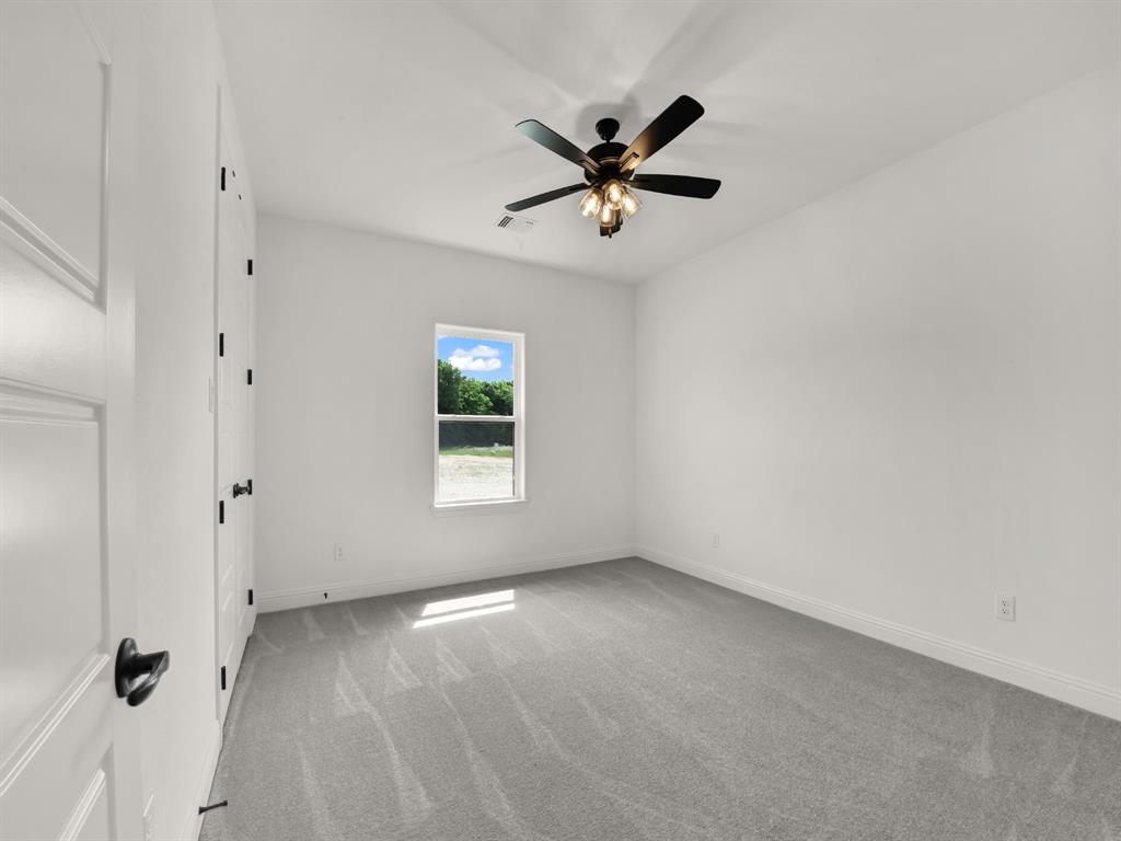 143 Desperado Way Weatherford, TX 76088 - Photo 32 of 36 Unfurnished room with light carpet, baseboards, and ceiling fan
