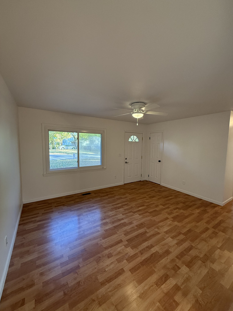 1309 Maplepark Drive Champaign, IL 61821 - Photo 3 of 24 an empty room with wooden floor and windows