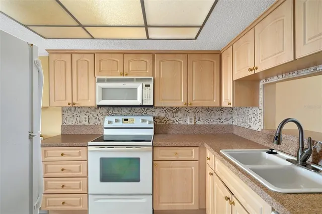 a kitchen with stainless steel appliances granite countertop a sink and a white cabinets
