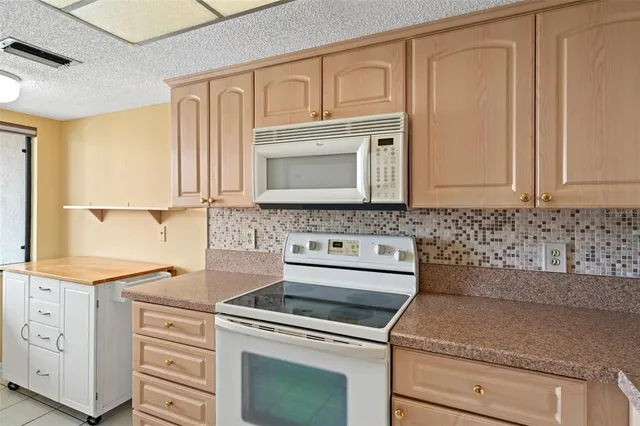 a kitchen with stainless steel appliances granite countertop a refrigerator a stove and a sink with granite countertops