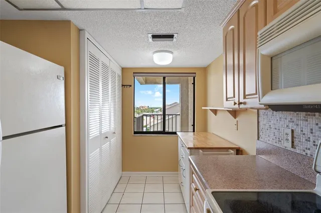 a kitchen with a sink a refrigerator and cabinets