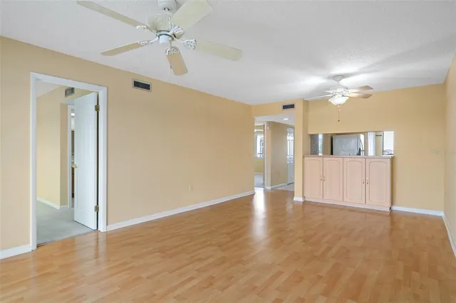 a view of a hallway with wooden floor and cabinet