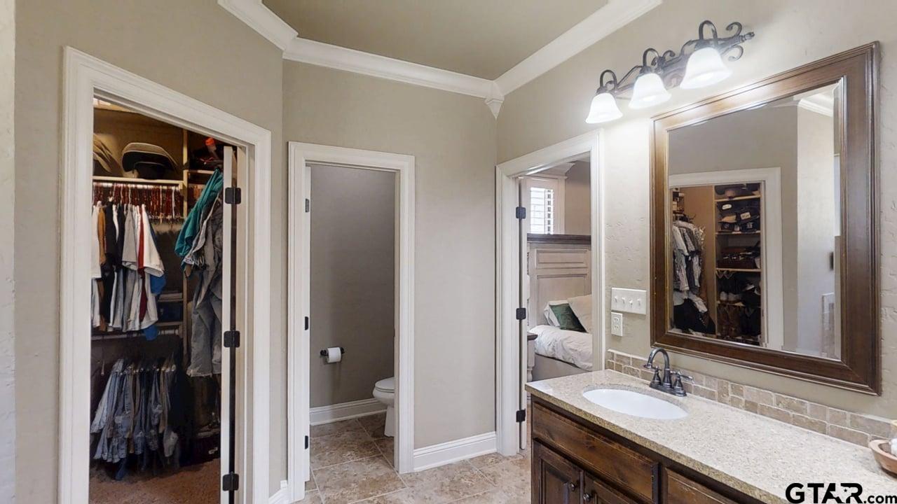 809 Crepe Myrtle Lane Longview, TX 75604 - Photo 22 of 39 a en suite bathroom with a sink and a mirror