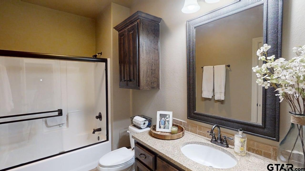 809 Crepe Myrtle Lane Longview, TX 75604 - Photo 25 of 39 a bathroom with a granite countertop sink toilet and shower
