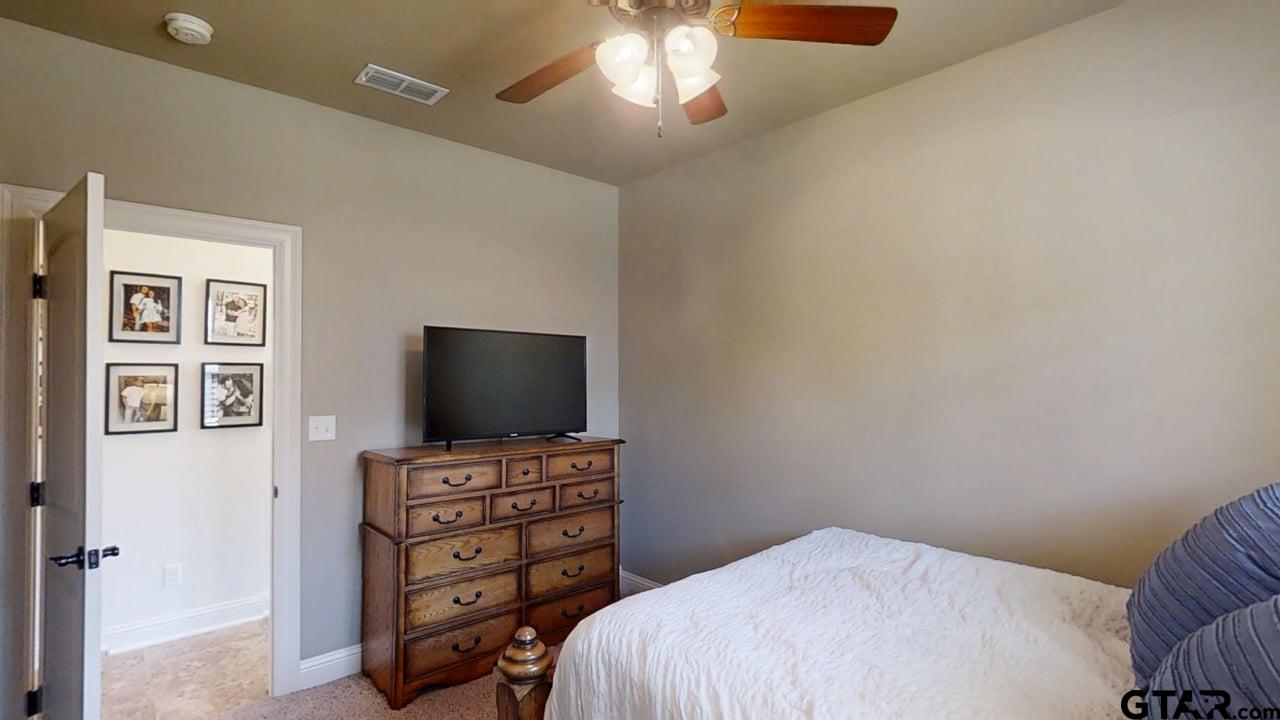 809 Crepe Myrtle Lane Longview, TX 75604 - Photo 27 of 39 a bedroom with a bed and a flat screen tv