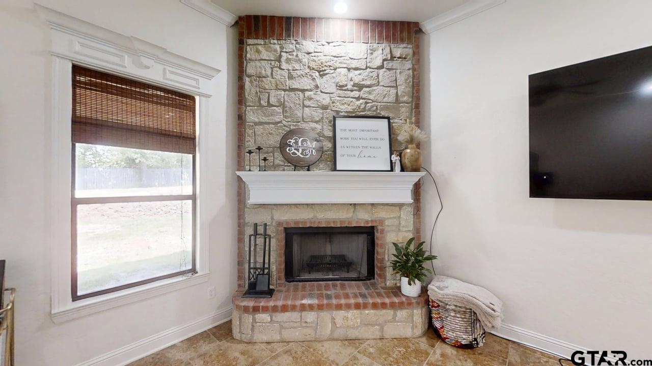 809 Crepe Myrtle Lane Longview, TX 75604 - Photo 5 of 39 a living room with a fireplace and a flat screen tv