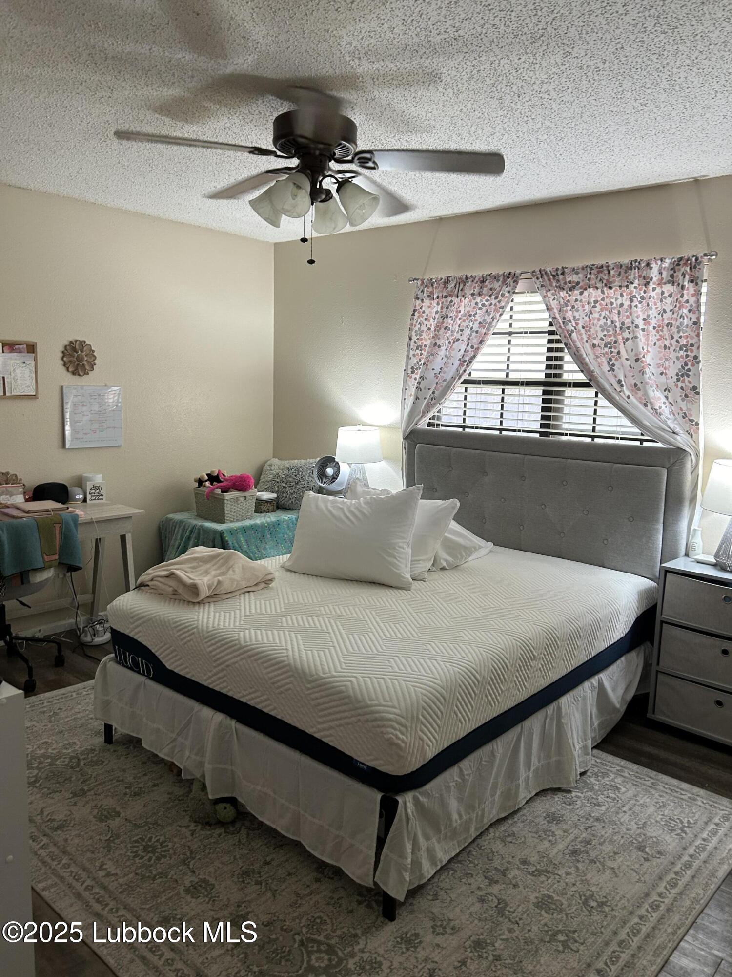 4809 8th Street Lubbock, TX 79416 - Photo 15 of 15 a bedroom with a bed a chandelier and a window