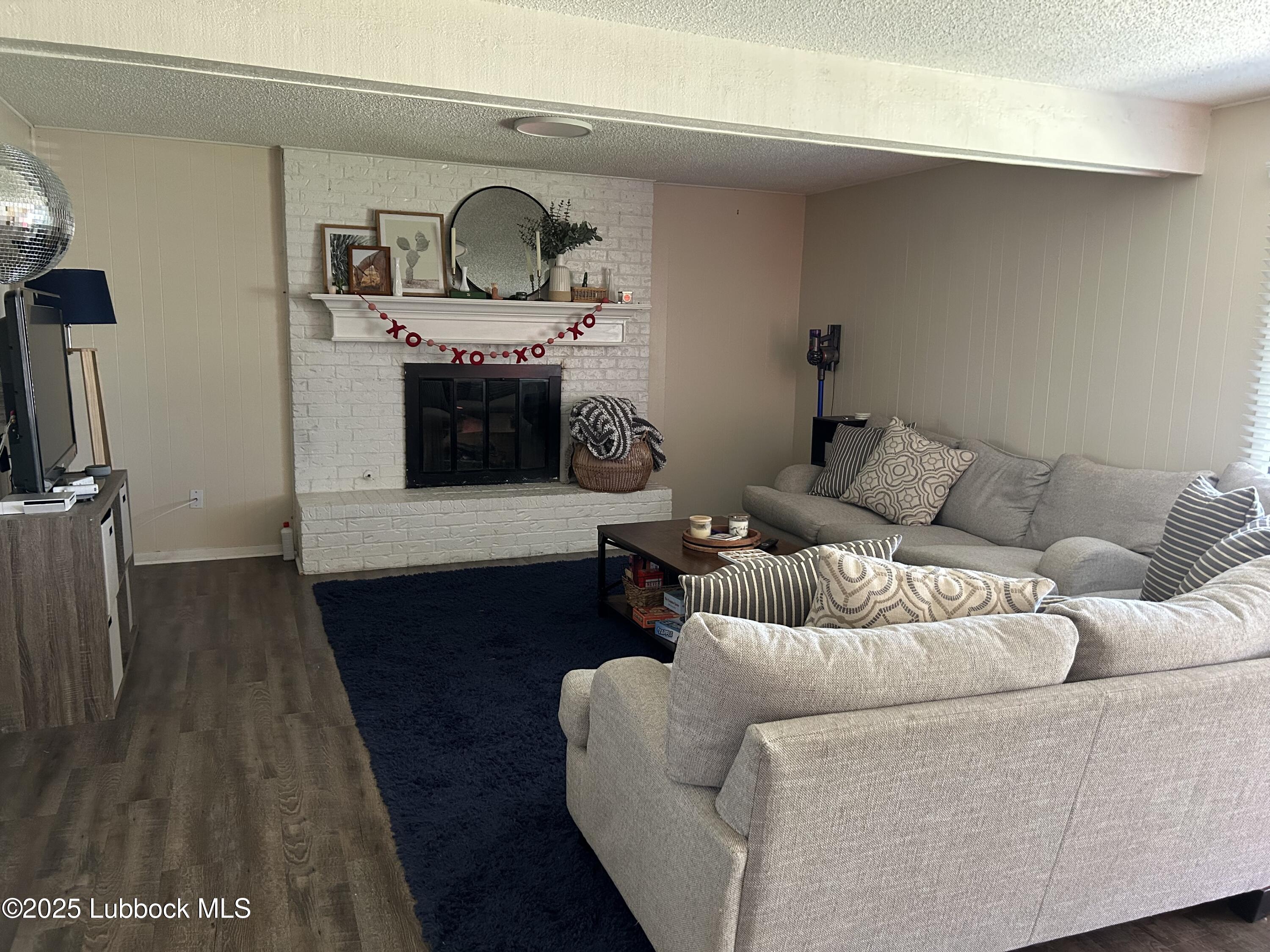 4809 8th Street Lubbock, TX 79416 - Photo 2 of 15 a living room with furniture and a fireplace