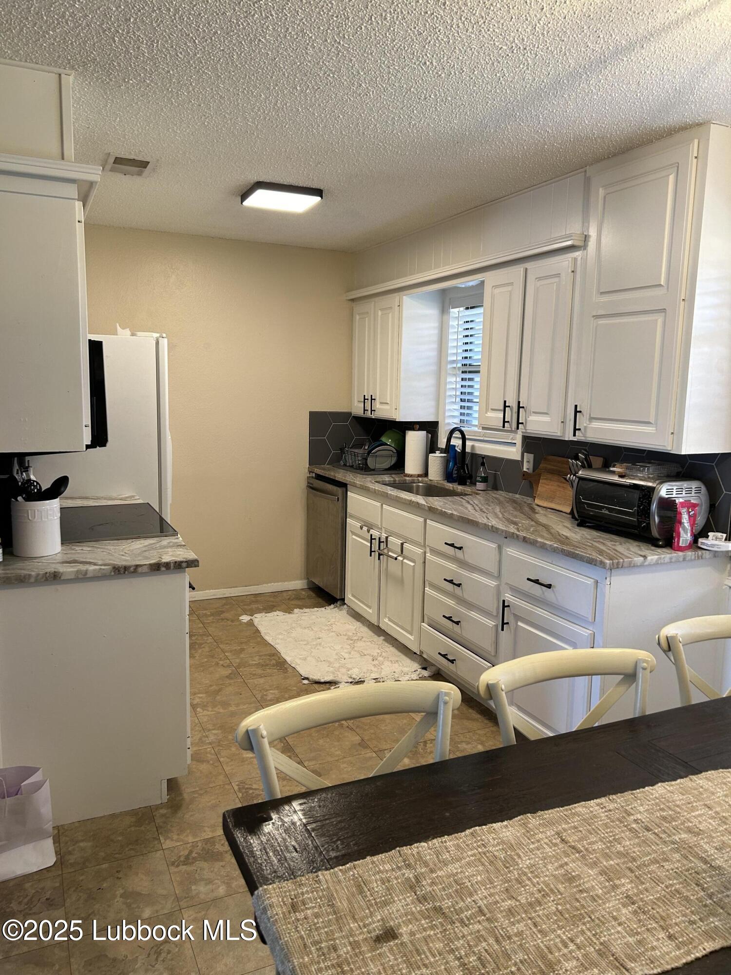 4809 8th Street Lubbock, TX 79416 - Photo 4 of 15 a kitchen with stainless steel appliances kitchen island granite countertop a sink and cabinets