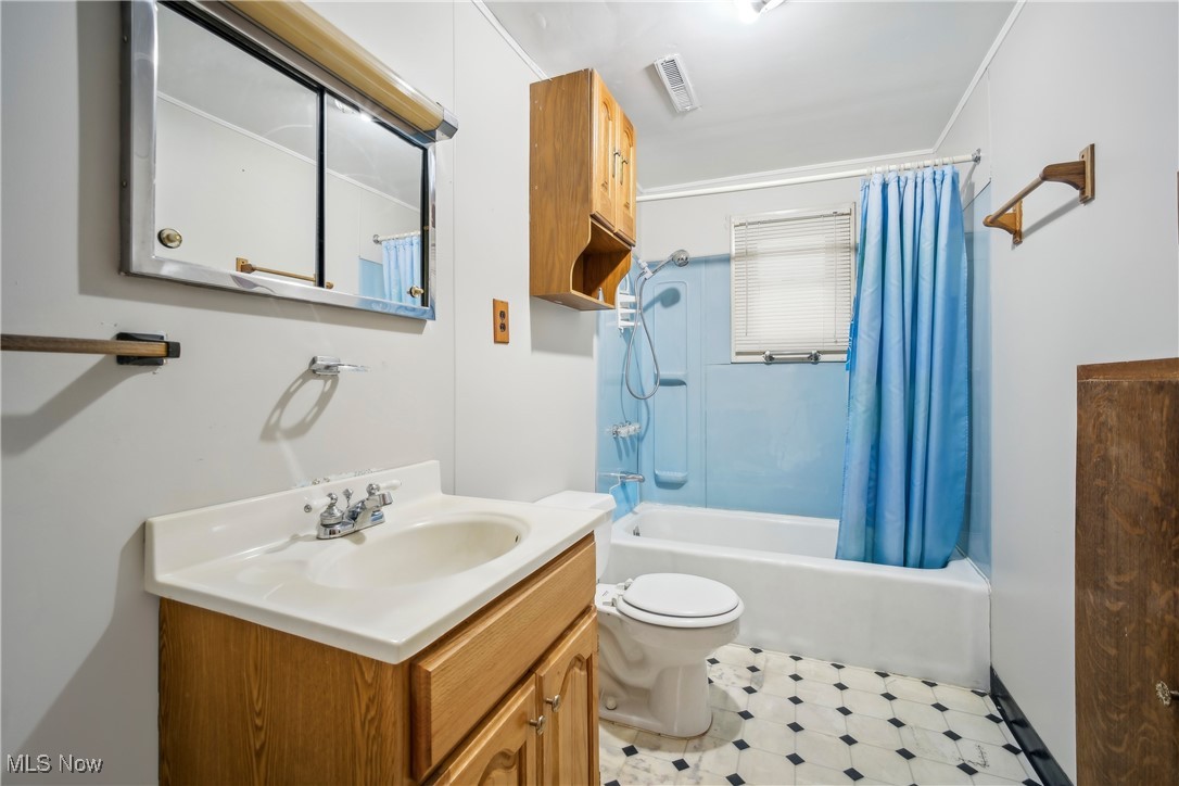 754 Fettro Road Akron, OH 44312 - Photo 16 of 31 Full bathroom featuring vanity, visible vents, tile patterned floors, toilet, and shower / tub combo with curtain