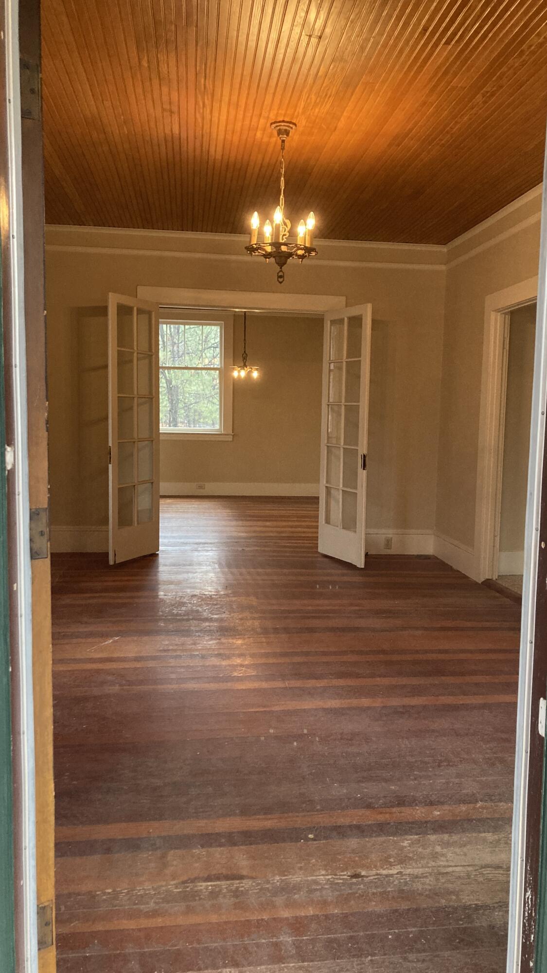 41008 Old School Road Fall River Mills, CA 96028 - Photo 6 of 53 en empty room with wooden floor chandelier and windows