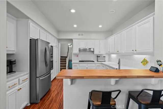 a kitchen with stainless steel appliances lots of counter space and refrigerator