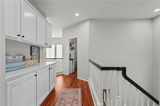 a view of hallway with wooden floor and cabinet