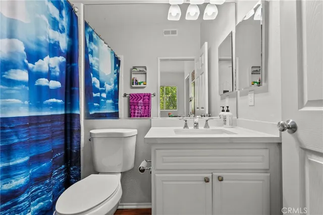 a bathroom with a toilet a sink and a large mirror