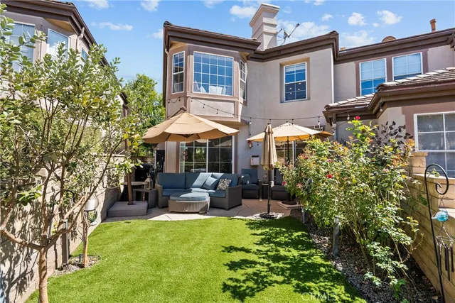 a patio with sofas table and chairs and potted plants