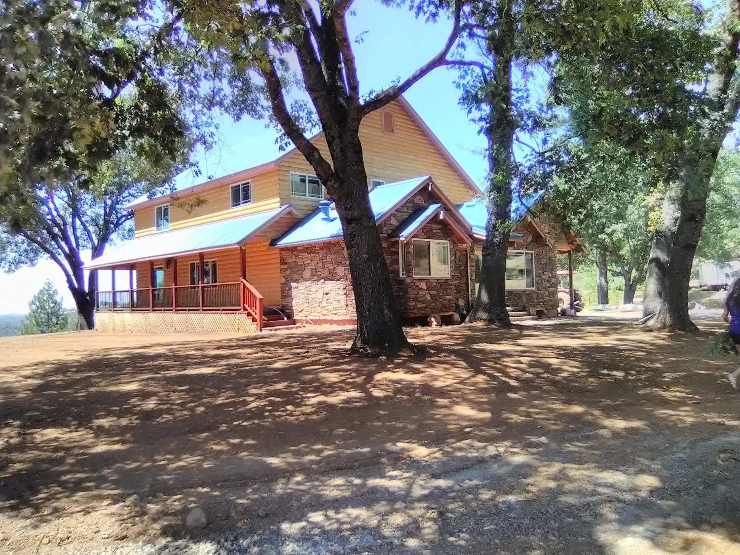 a front view of a house with a tree