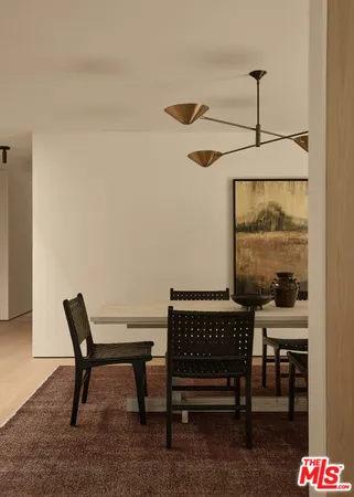 a view of a hallway with chairs and a table in a room