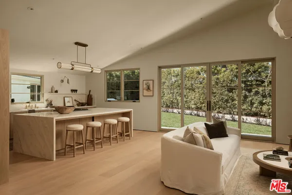 a living room with furniture a large window and a dining table