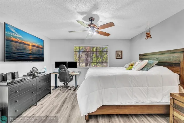 a bedroom with a bed a window and a flat screen television