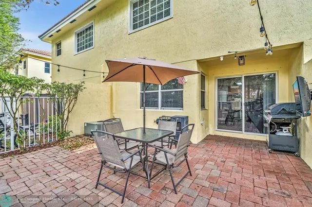 a view of a patio with a table and chairs under an umbrella
