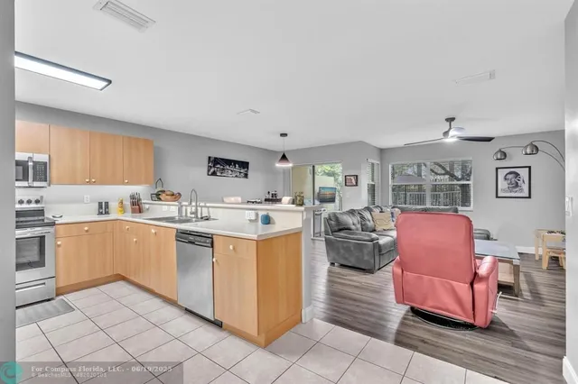 a kitchen with stainless steel appliances granite countertop a refrigerator a sink a stove with cabinets