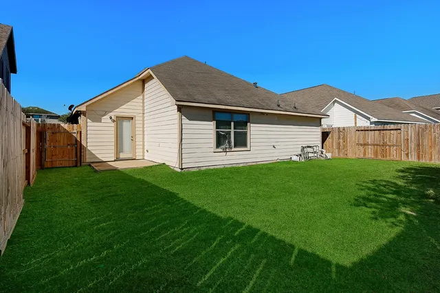 a view of a backyard with wooden fence