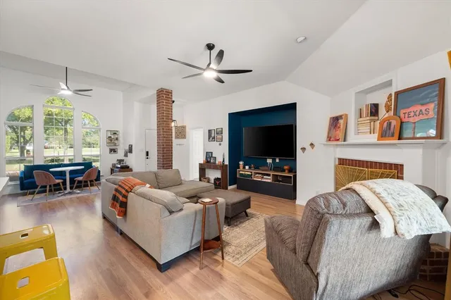 a living room with furniture a flat screen tv and a fireplace