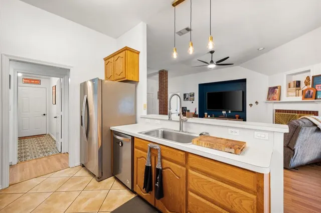 a kitchen with stainless steel appliances granite countertop a sink and a refrigerator