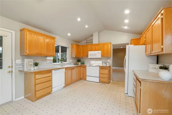 a kitchen with granite countertop refrigerator sink and stove