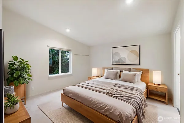 a bedroom with a large bed and a potted plant