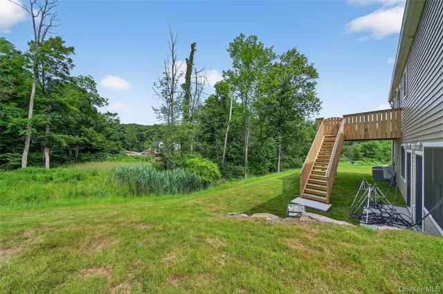 a view of a backyard with a large tree and wooden fence