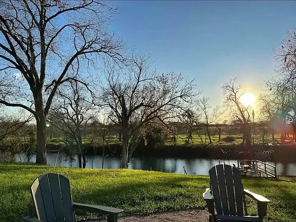 a view of a lake with a table and chairs