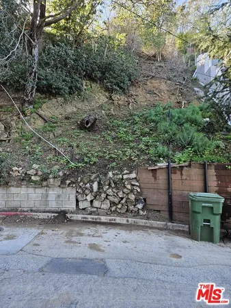 a view of a street with wooden fence