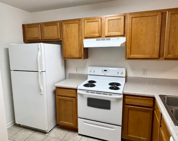 a kitchen with a stove top oven and refrigerator
