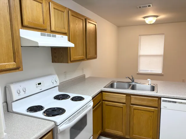 a kitchen with a sink a stove and cabinets