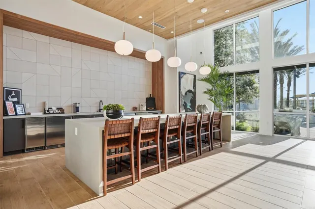 a kitchen with stainless steel appliances kitchen island granite countertop a stove a sink a dining table and chairs with wooden floor