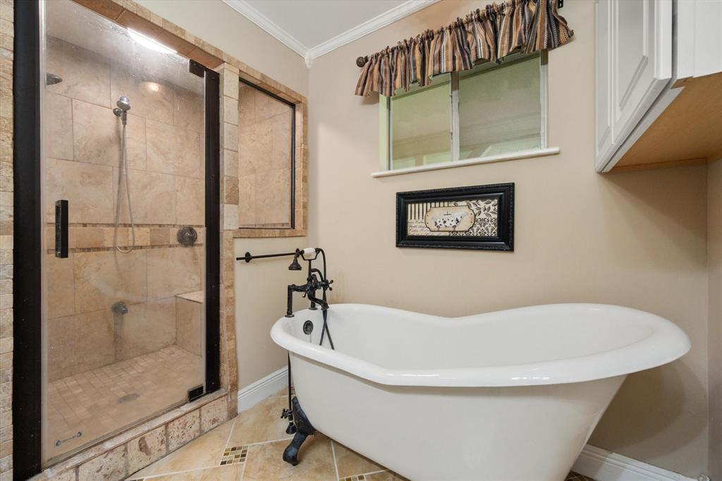 14036 Old Texaco Road Conroe, TX 77302 - Photo 13 of 40 Full bath with crown molding, a shower stall, baseboards, a freestanding tub, and tile patterned floors