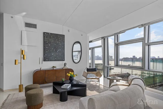 a living room with couches and a large window with garden view