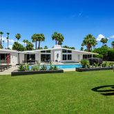 a front view of a house with garden and outdoor seating