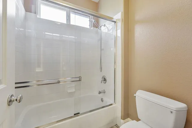 a spacious bathroom with a granite countertop sink a mirror and a shower
