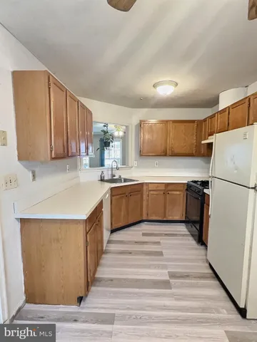 a kitchen with a sink a refrigerator and a stove top oven