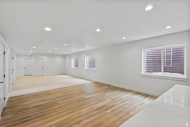 728 East Mountain Road North Ogden, UT 84414 - Photo 20 of 28 Spacious room featuring wood-finish flooring and neutral carpet, white walls, multiple recessed lights, and several white doors with black hardware