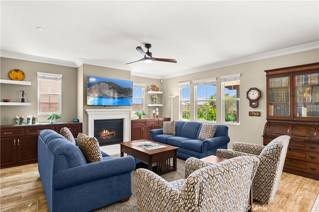 4976 Golden Ridge Place Rancho Cucamonga, CA 91739 - Photo 21 of 56 Lighted ceiling fan in family room with custom cabinetry in the alcoves and a gas burning fireplace
