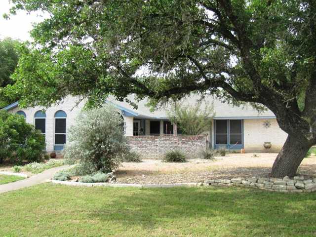 a front view of house with yard and trees around