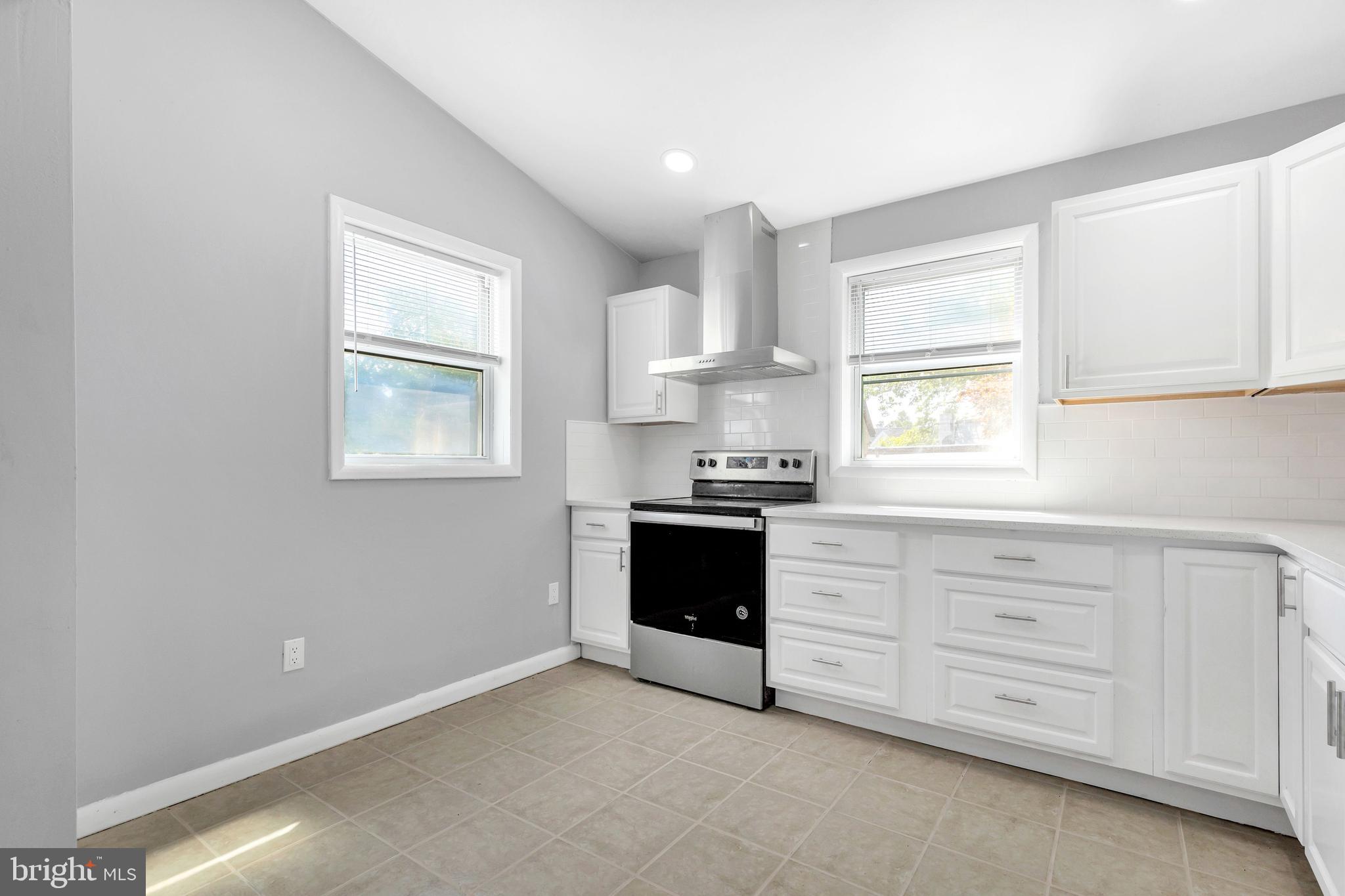 120 Englewood Road Upper Darby, PA 19082 - Photo 13 of 29 a kitchen with granite countertop white cabinets and a window