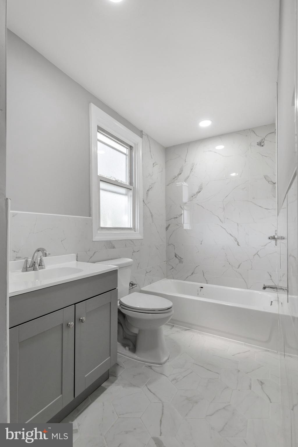 120 Englewood Road Upper Darby, PA 19082 - Photo 19 of 29 a bathroom with a toilet a sink a mirror a bathtub and vanity
